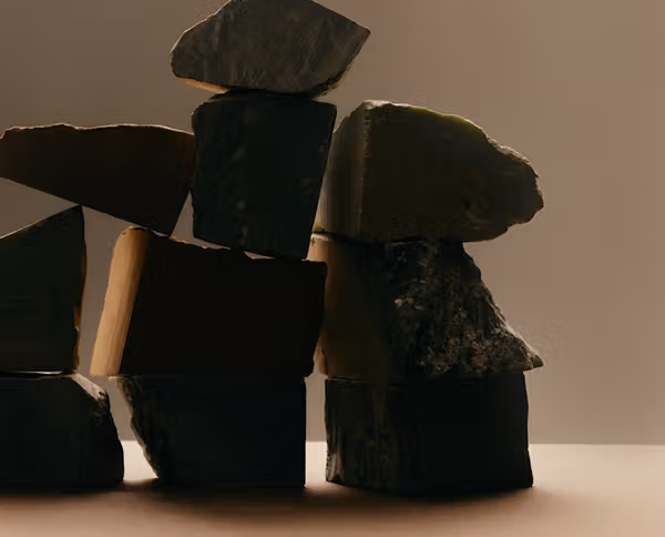 Rough dark stones balanced into an abstract sculpture.